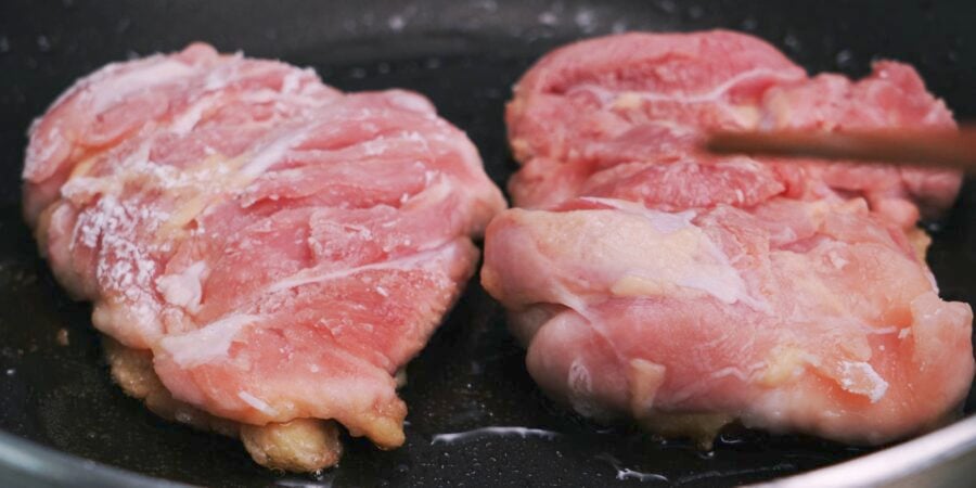 Frying chicken teriyaki, skin-side down.