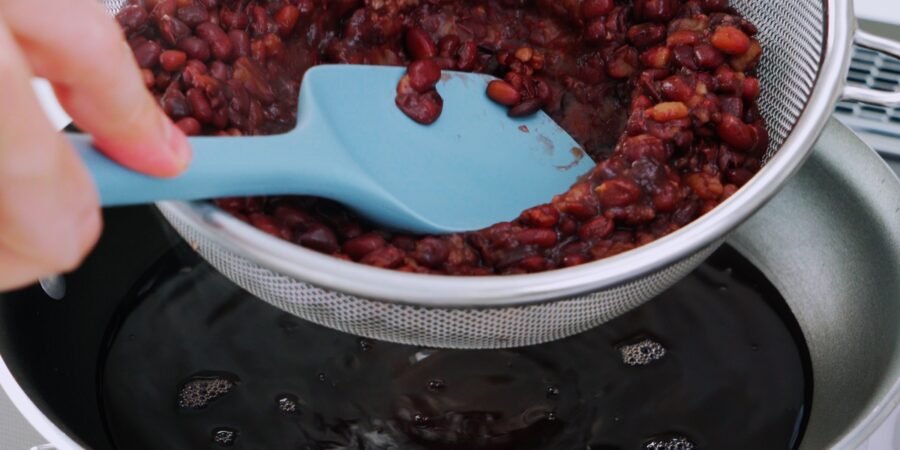 Separating the cooking liquid from the Adzuki beans.
