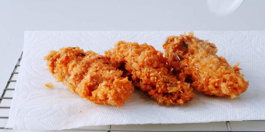 Crispy deep fried oysters draining on paper towels.
