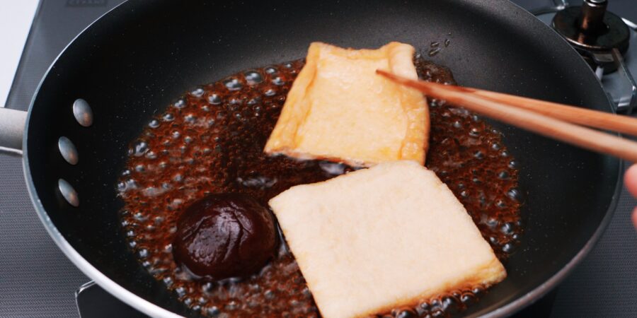 Making Inari Agé with fried tofu, soy sauce, sugar and sake.