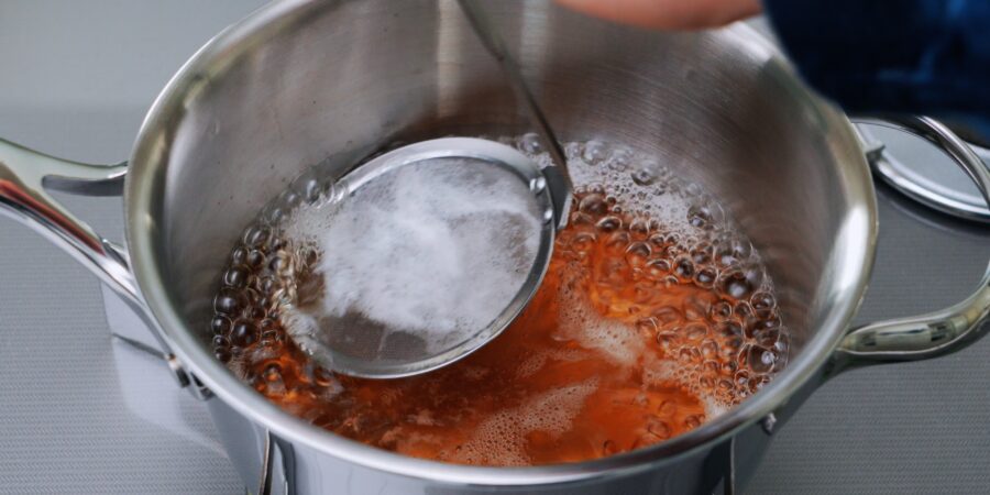 Skimming vegan udon broth.