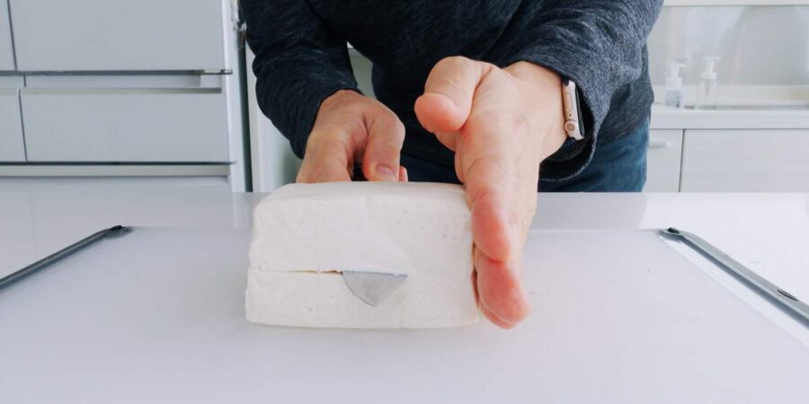 Slicing block of tofu into steaks.