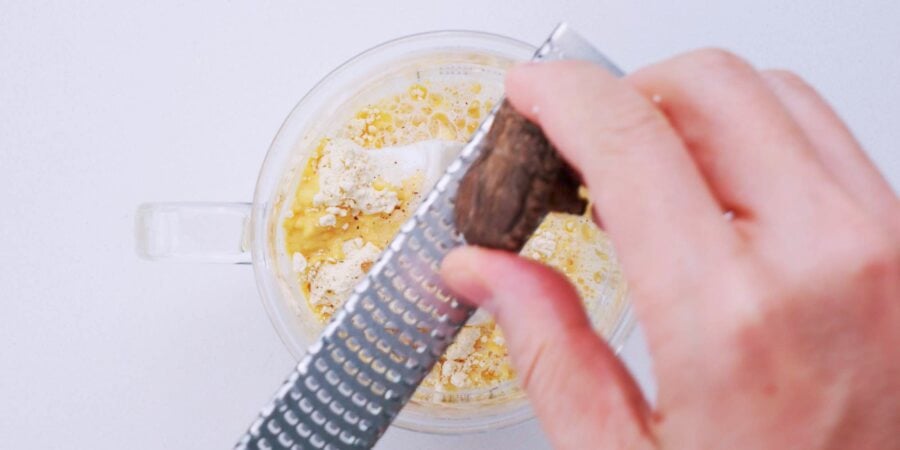 Grating dried shiitake mushrooms into a powder.