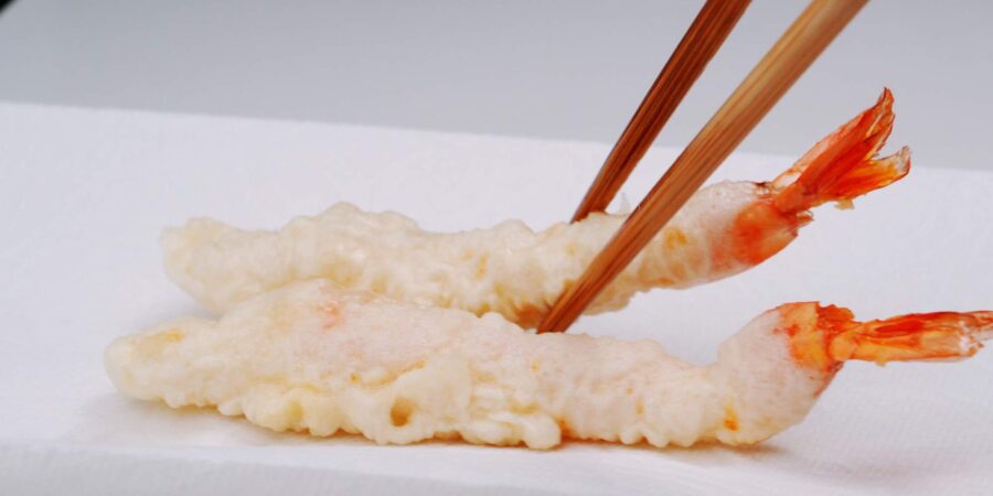 Shrimp tempura draining on paper towels.