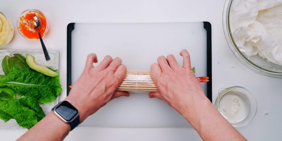 Rolling sushi with a sushi mat.