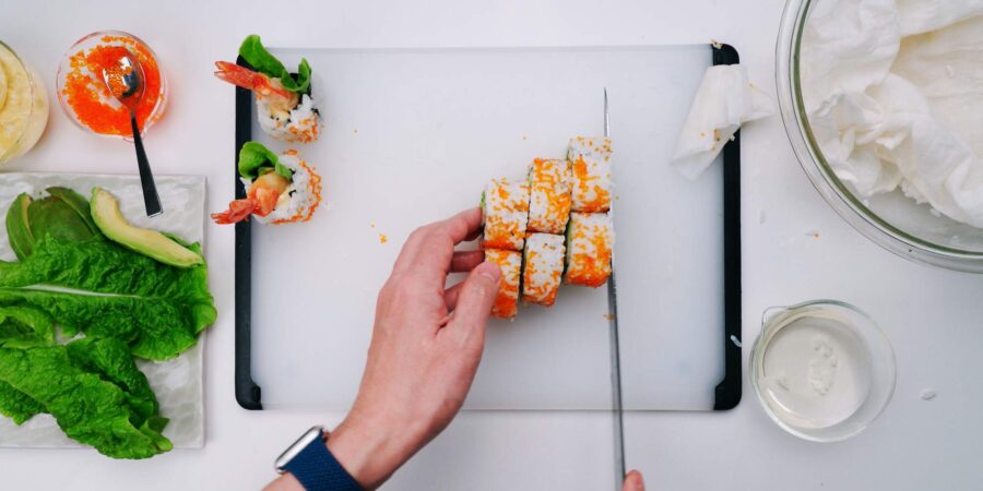 Slicing shrimp tempura sushi roll.