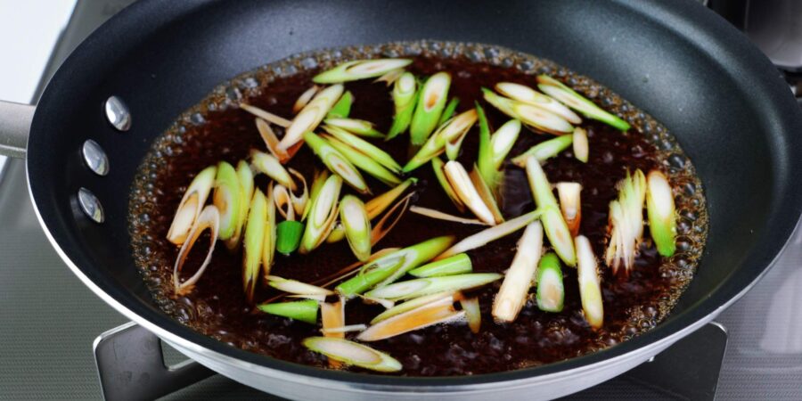 Scallion stems simmering in savory sweet dashi broth.