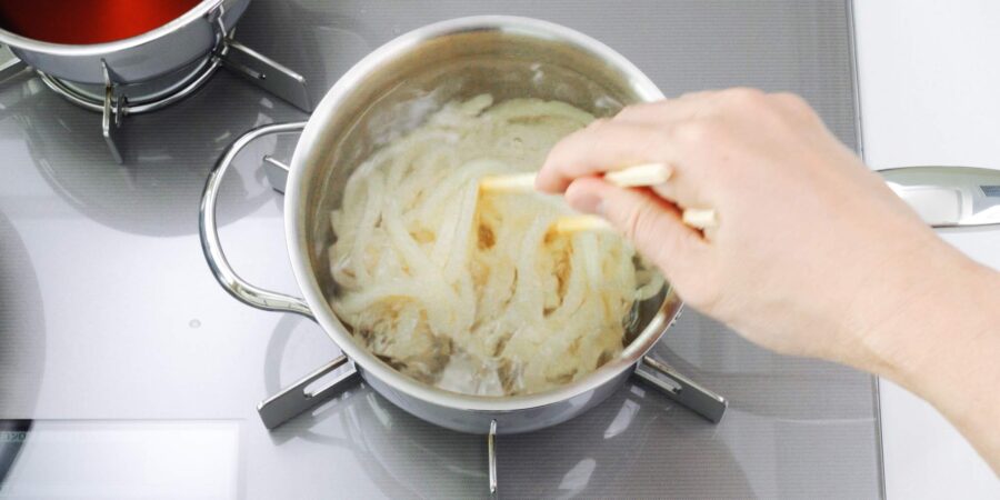 Boiling udon noodles.