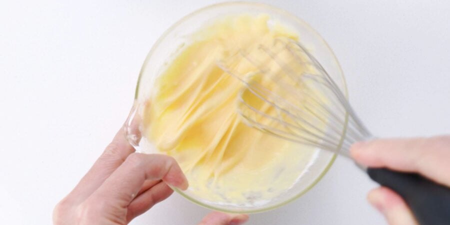 Whisking egg, water and flour batter in a bowl until free of lumps.