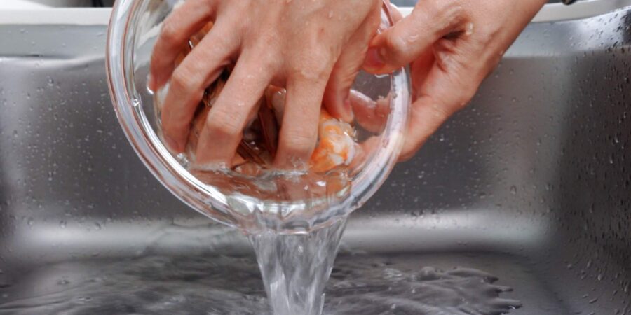 Rinsing shrimp with cold water.