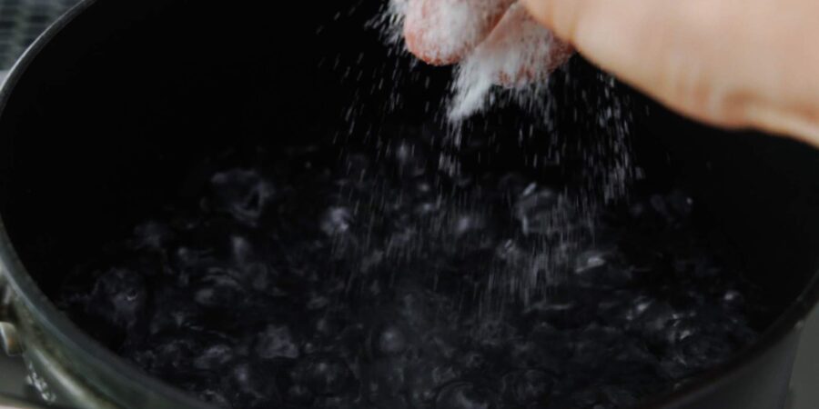 Salting boiling water for pasta.