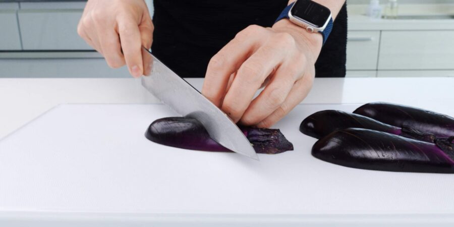 Scoring eggplant skin with knife.