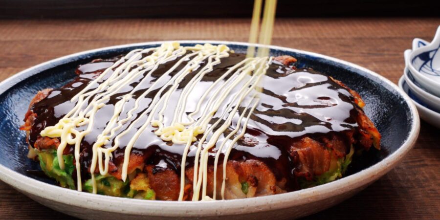 Japanese savory pancake glazed with Okonomiyaki sauce and drizzled with mayonnaise.