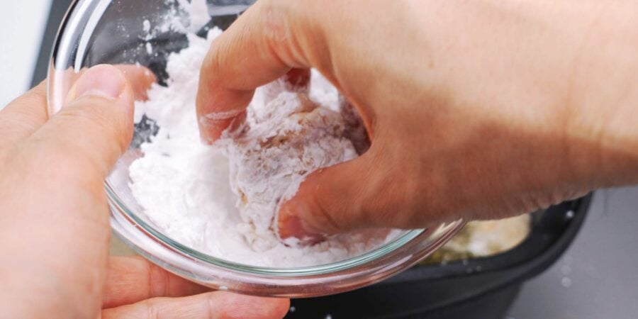 Dusting karaage chicken with potato starch.