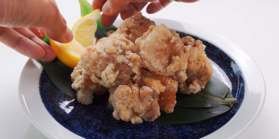 Plating Japanese fried chicken with lemon wedges.
