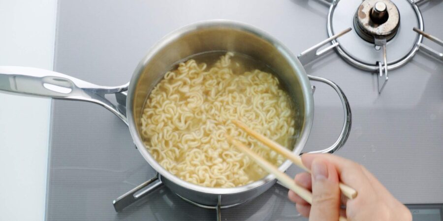 Boiling instant ramen noodles.