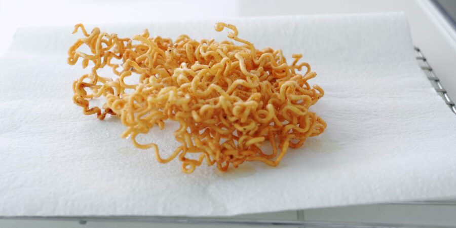 Fried ramen noodles draining on paper towels.