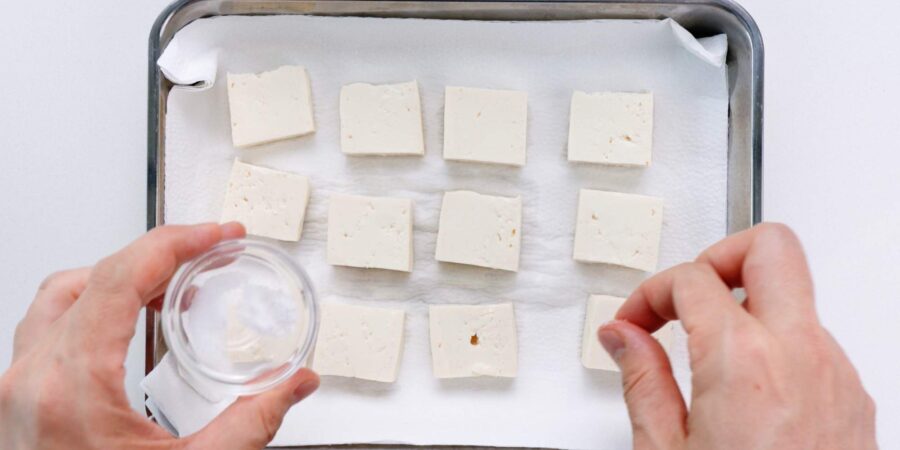 Salting and draining firm tofu.