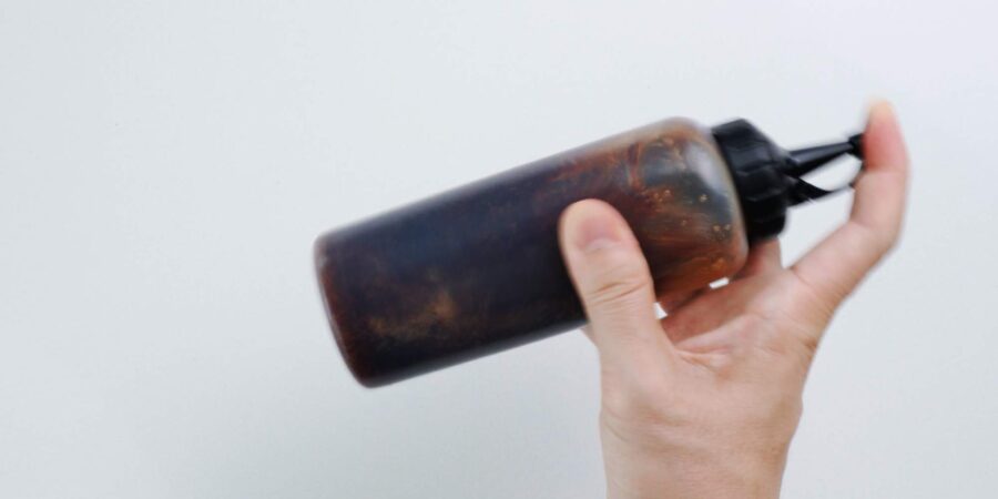 Shaking a bottle of homemade teriyaki sauce.