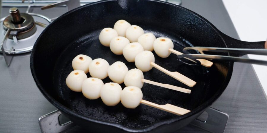 Charred Mitarashi Dango in a cast iron skillet.