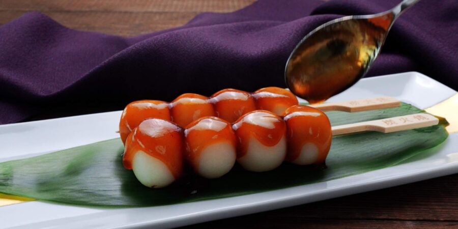 Glazing Mitarashi Dango with sauce.
