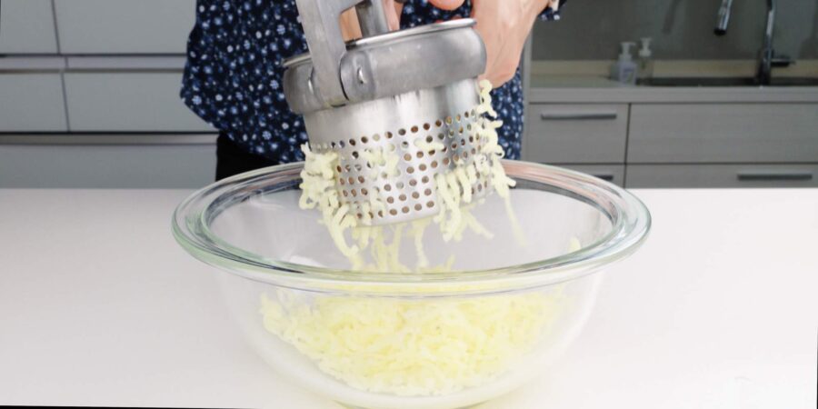 Mashing potatoes using a ricer.