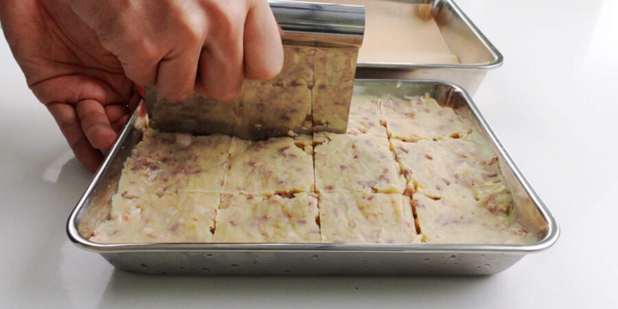 Dividing korokke filling with a pastry knife.