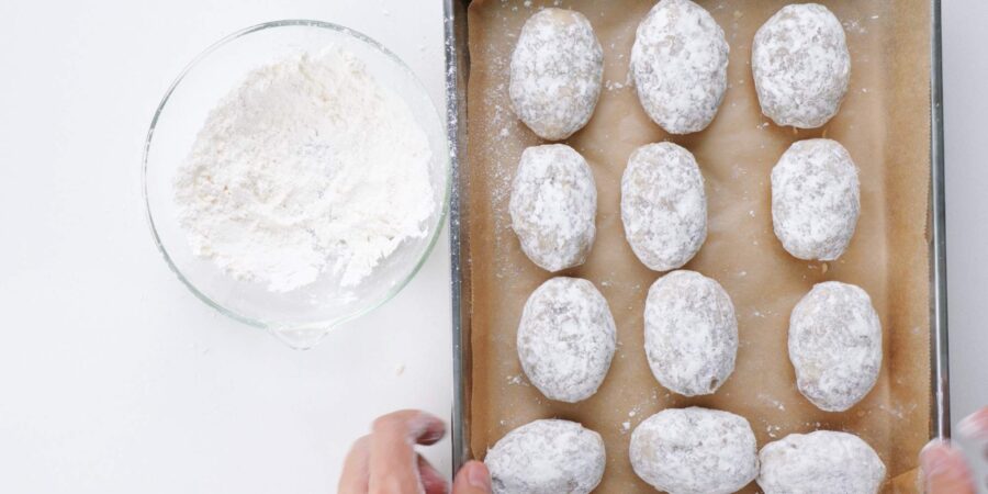 Dusting croquette patties with flour.