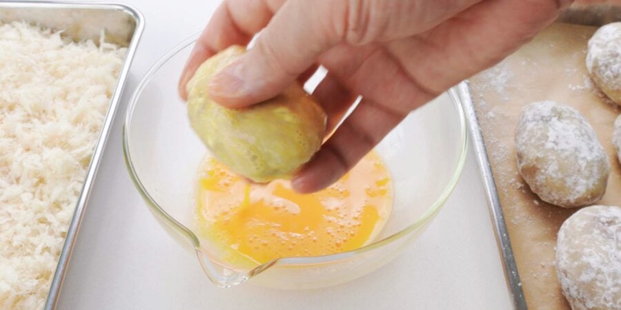 Coating korokke with egg.