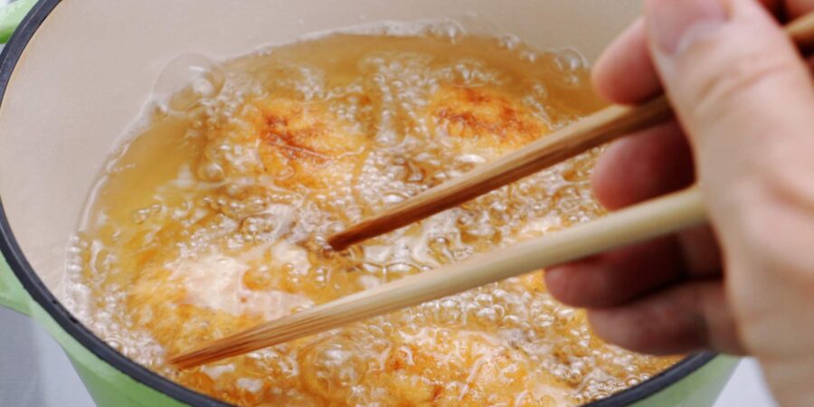 Deep frying korokke.