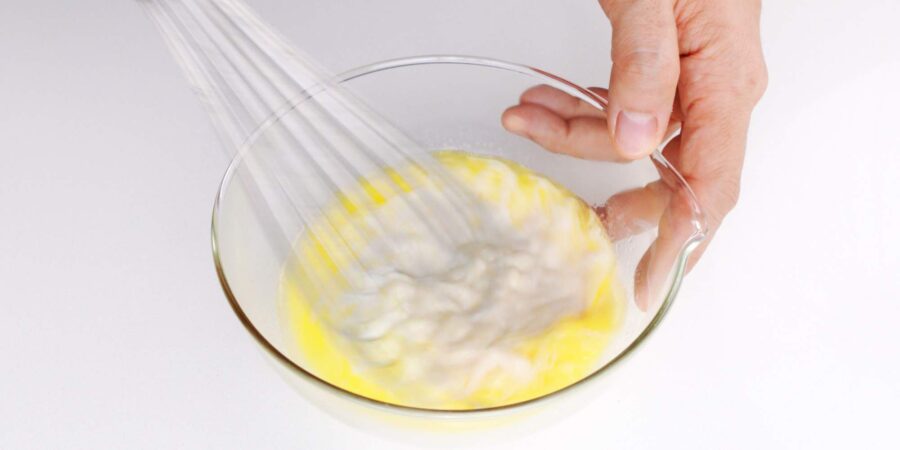 Whisking butter and milk together in a bowl for making Taiyaki Batter.