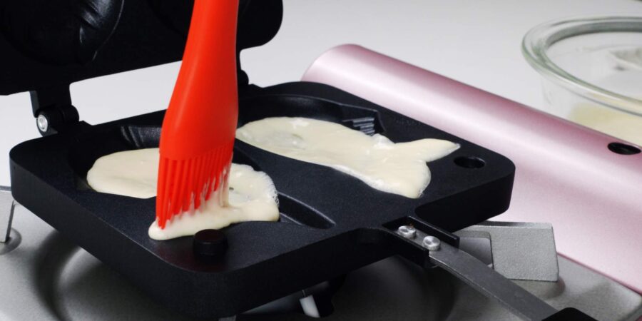 Using a brush to spread the batter.