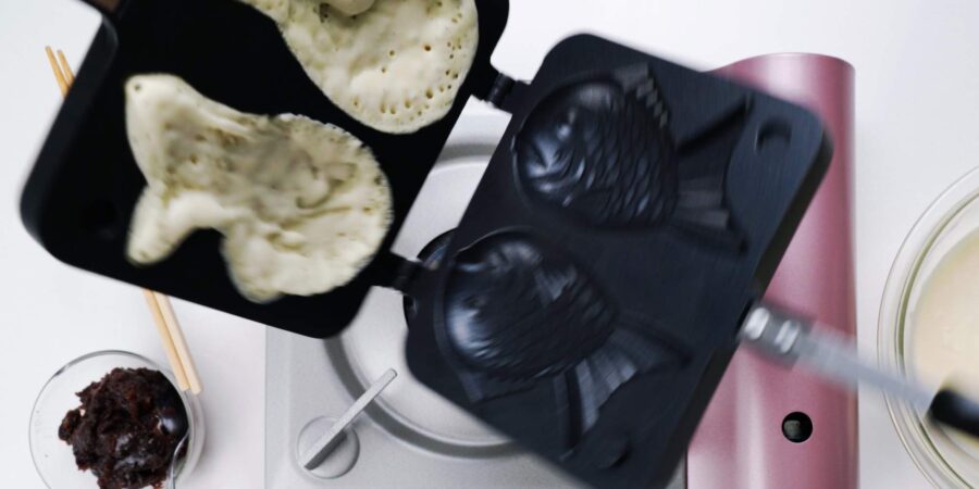 Flipping the taiyaki pan over.