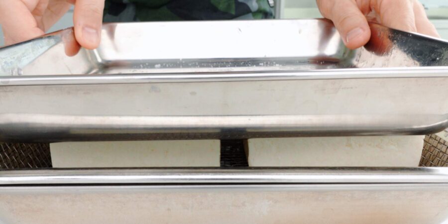 Press tofu with a weighted tray.
