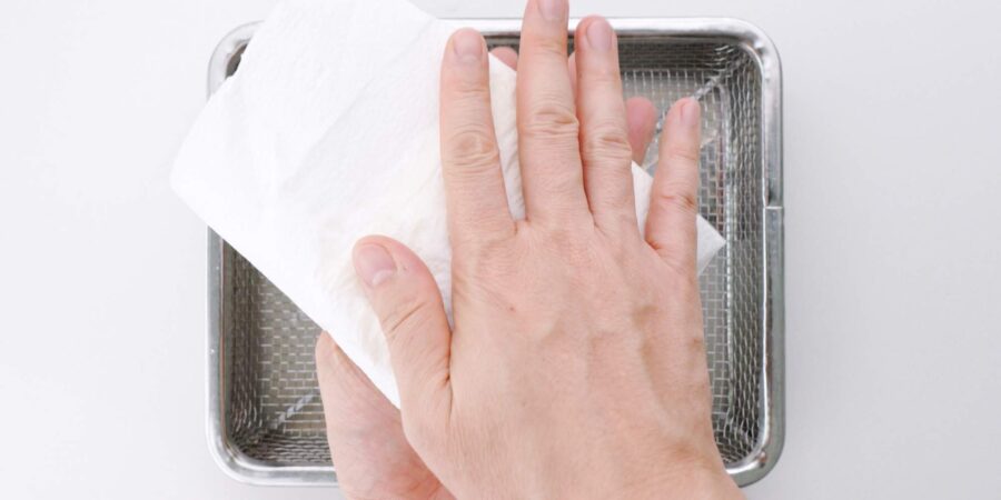 Drying off tofu with paper towels.