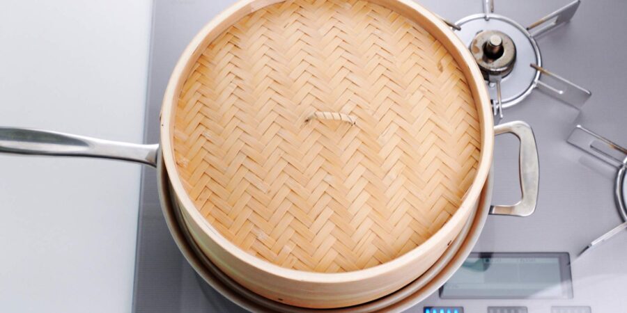 Bamboo steamer basket steaming dumplings.