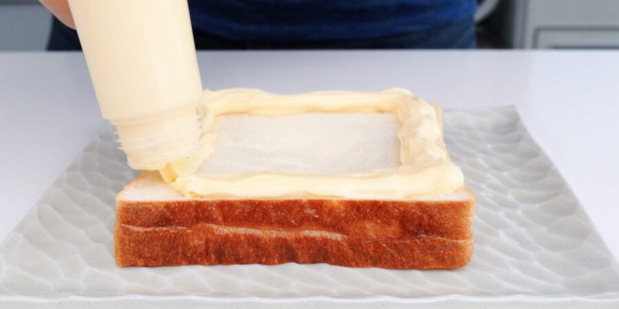 Pipe a border around the edge of the bread with mayonnaise.