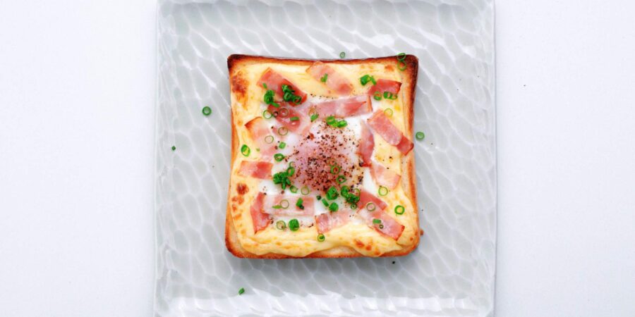 Japanese egg toast topped with bacon and scallions.