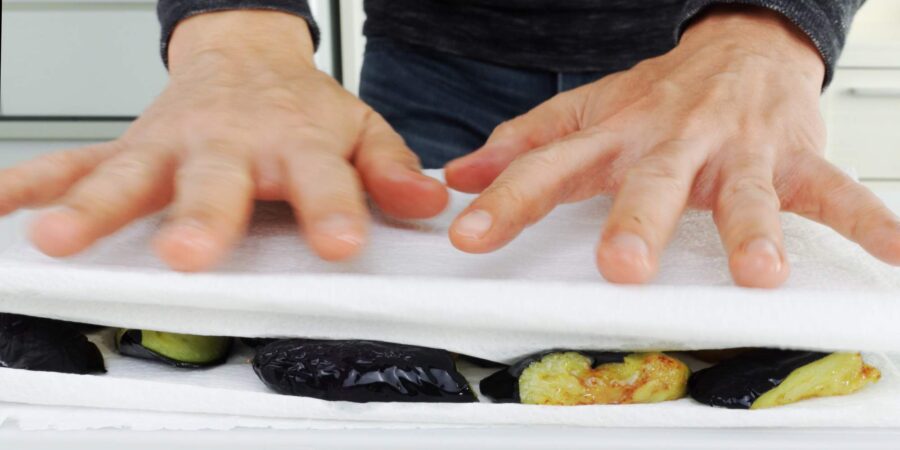 Draining eggplant of excess oil.