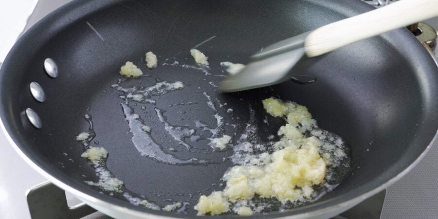 Stir-frying ginger and garlic in a frying pan.