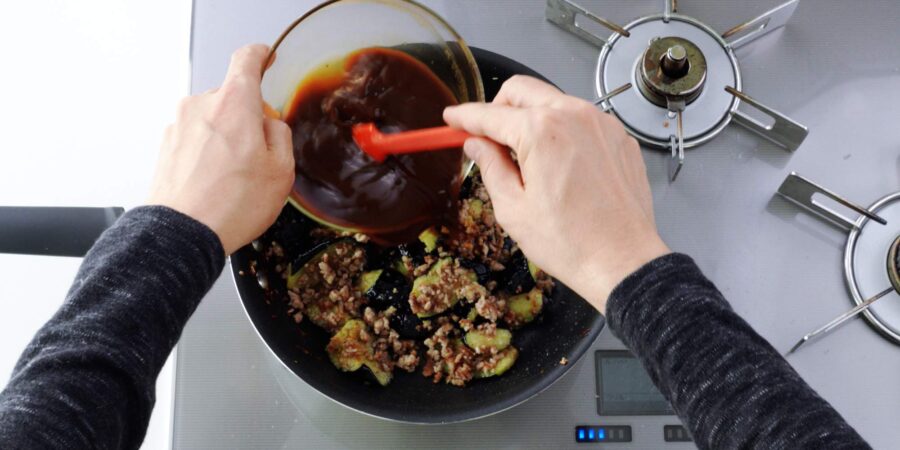 Adding mapo sauce to meat and eggplant mixture.