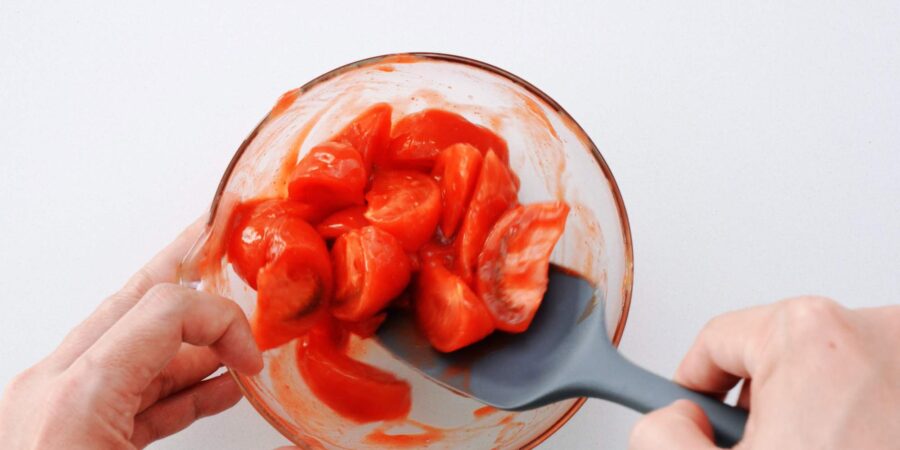 Mixing tomatoes with seasonings.