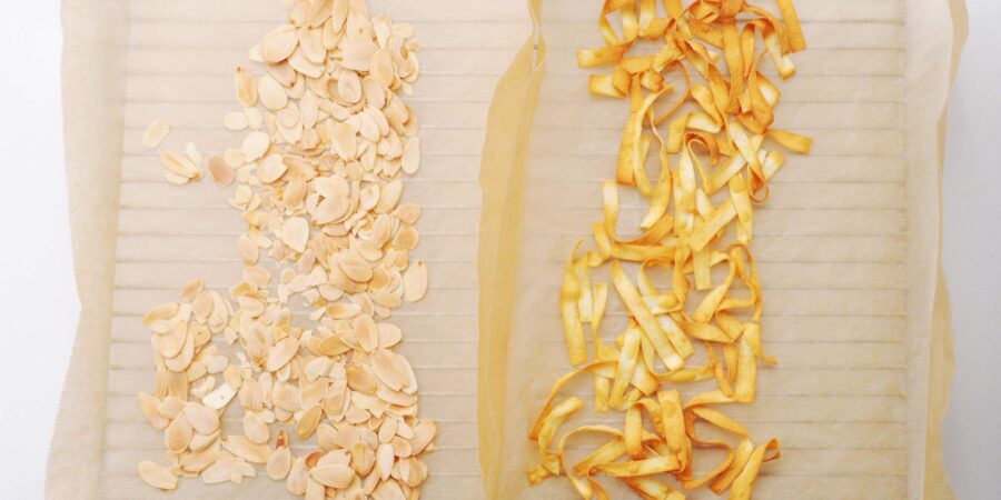 Toasted almonds and wonton strips on a cooling rack.