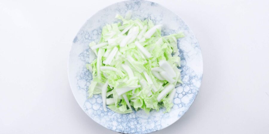 Shredded napa cabbage mounded on a plate.