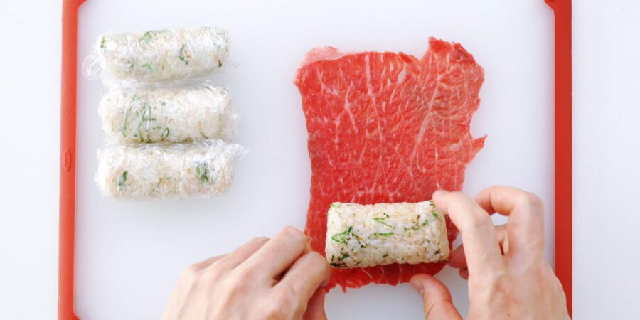 Wrapping onigiri in thin sheets of beef.