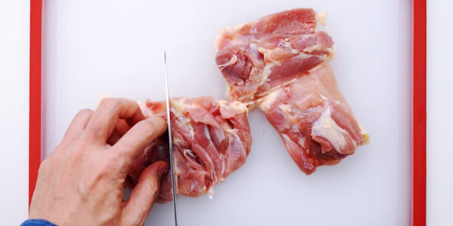 Cutting chicken thigh.