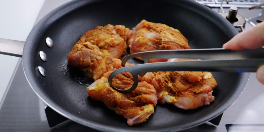 Pan-frying chicken on the skin-side.