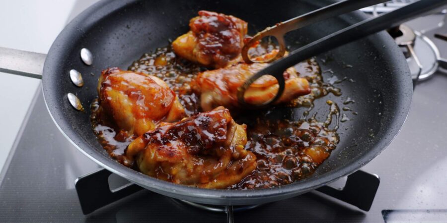 Glazing chicken with mango chutney.
