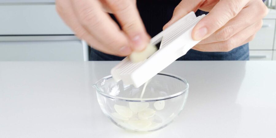 Slicing garlic chips using mandoline.