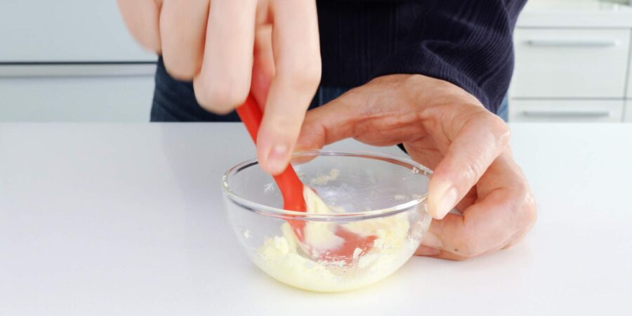 Mashing butter and grated garlic together.